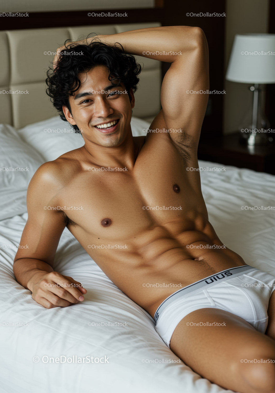Smiling young man relaxing on bed in white underwear
