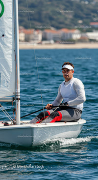 Man Sailing a Small Yacht in Blue Ocean Water