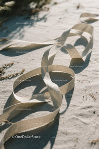 Close-up of White Plastic Ribbon Waste on Sandy Beach
