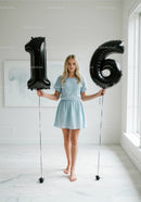 Teen girl celebrating sixteenth birthday with balloons
