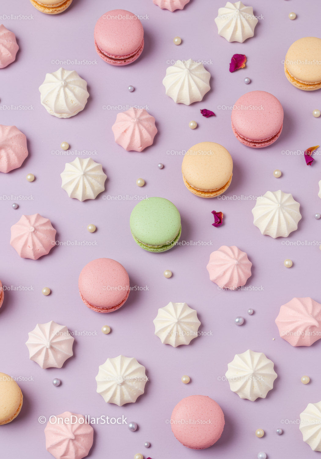 Colorful macarons and meringues on pastel purple background