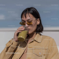 Stylish Woman Drinking Yellow Smoothie with Sunglasses on Beach