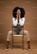 Stylish Confident Woman Sitting on Chair in Modern Studio