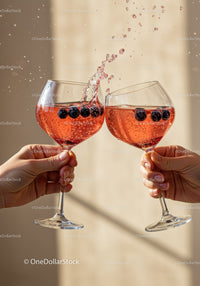 Two glasses clinking with sparkling berry cocktails
