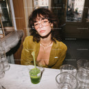 Stylish Young Woman Wearing Yellow Blouse with Glasses in Cafe