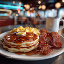 Fresh Breakfast Plate with Pancakes Bacon and Eggs in Cozy Cafe