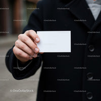 Person Holding Blank Business Card in Black Coat