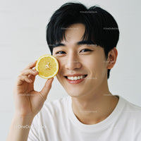 Smiling Young Man Holding Lemon Slice for Refreshing Summer Vibe