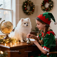 Girl in Elf Costume Ringing Bell with Fluffy Dog Indoors