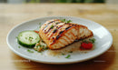 Fresh Grilled Salmon with Cucumber Cherry Tomato Garnish on White Plate