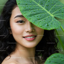 Portrait of a Smiling Woman with a Large Green Leaf Covering One Eye