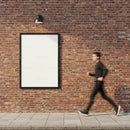 Motion blur of man passing empty billboard on brick wall