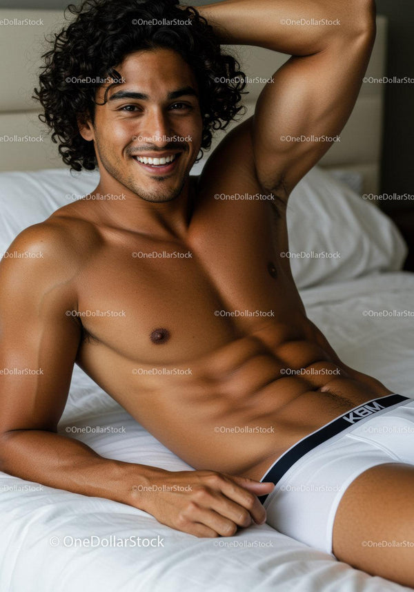 Smiling young man relaxing shirtless on bed
