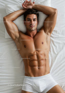 Fit young man resting on bed in white underwear