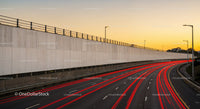 Highway at Sunset with Red Light Trails and City Street