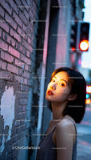 Young woman illuminated by warm urban light at dusk