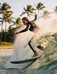 Focused Female Surfer Riding Ocean Wave at Sunset