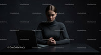 Thoughtful Woman at Laptop in Dark Modern Workspace