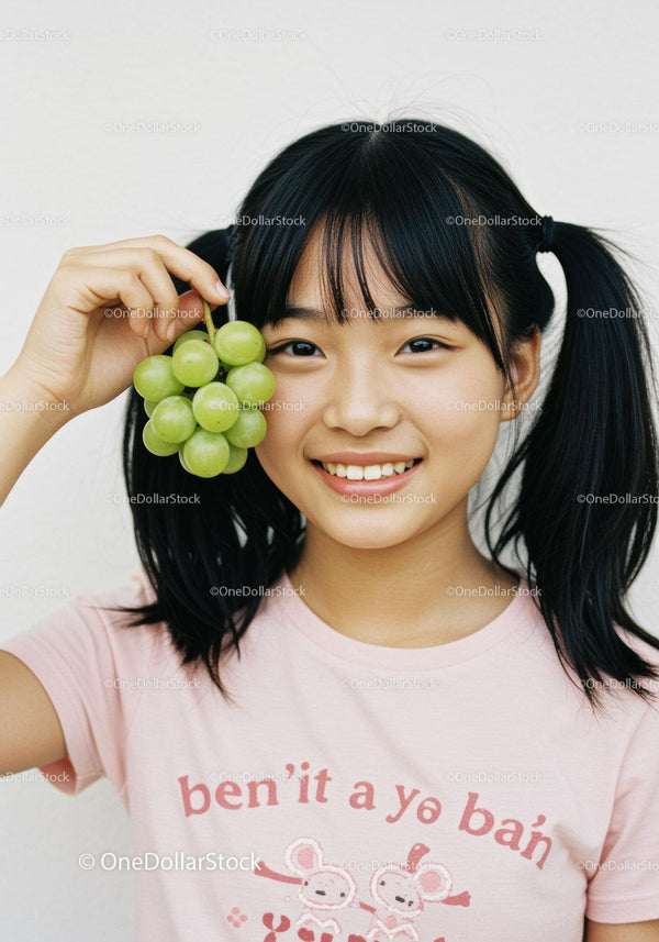 Happy Young Girl Holding Green Grapes with Big Smile