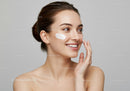 Smiling Woman Applying Facial Cream for Skincare Routine