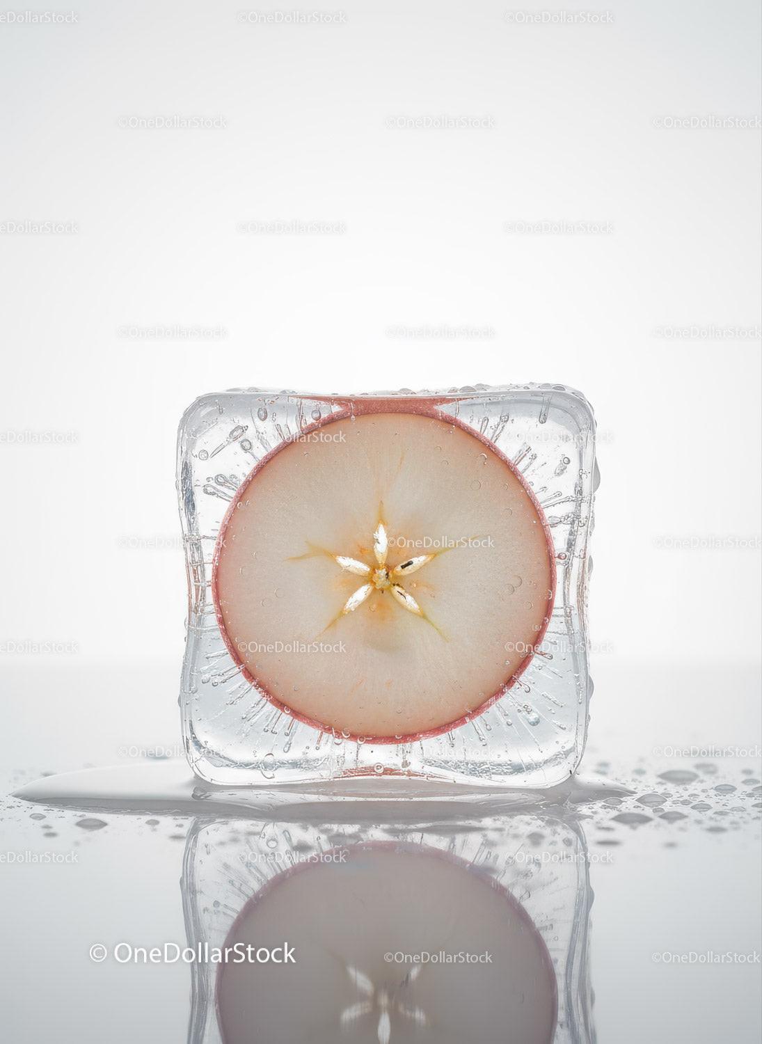 Fresh apple slice frozen within a clear ice cube