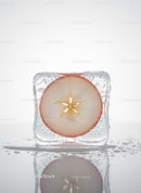 Fresh apple slice frozen within a clear ice cube