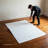 Person unrolling giant blank sheet on wooden floor