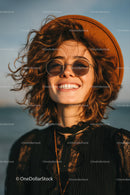 Beautiful smiling woman with curly hair wearing trendy hat and sunglasses