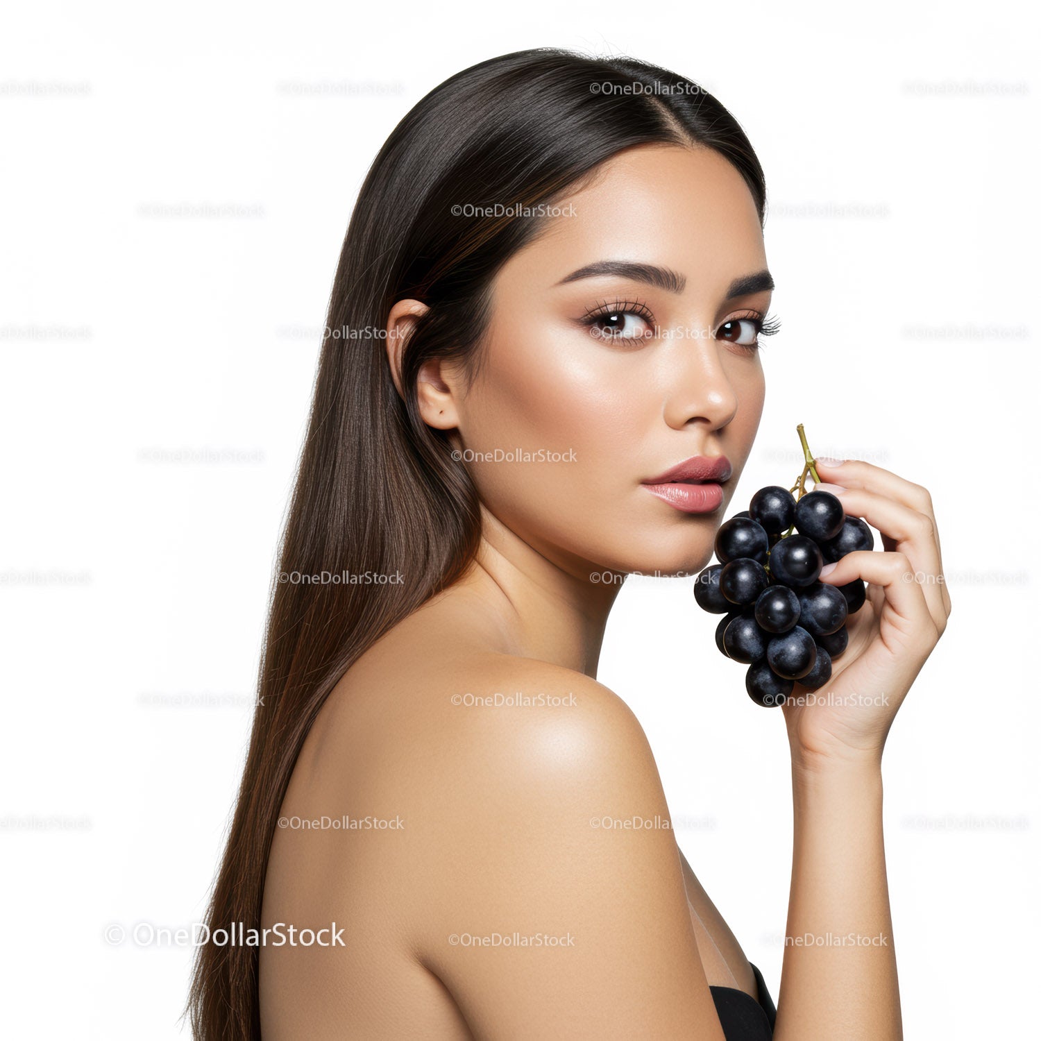 Elegant Young Woman with Dark Hair Holding Grapes for Health and Beauty