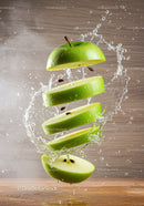 Fresh green apple slices suspended with splashing water