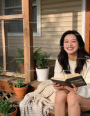 Smiling young woman enjoying her book outdoors