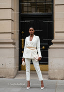 Confident woman in stylish white pantsuit with accessories