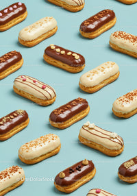 Variety of decorated éclairs on pastel blue background