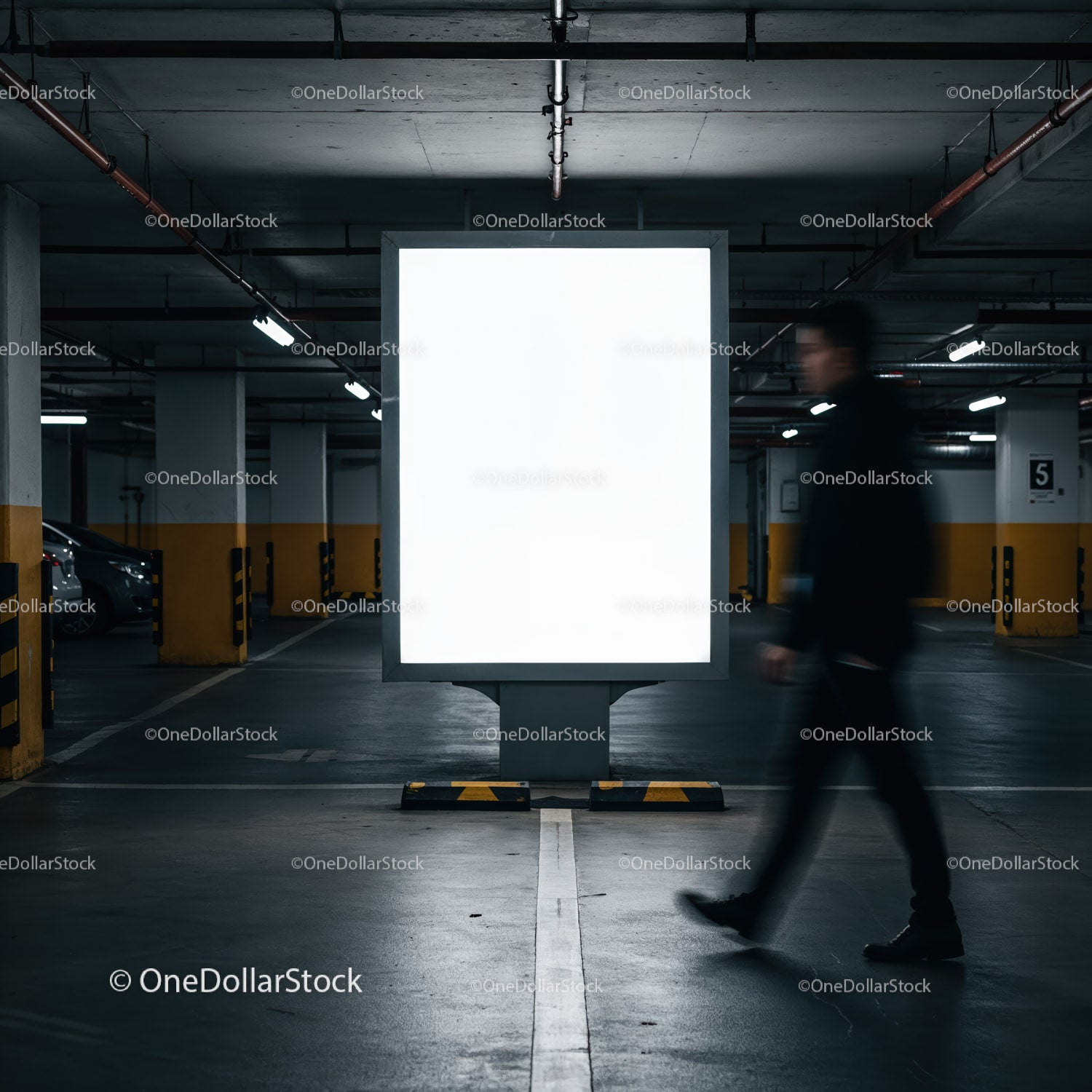 Niewyraźny mężczyzna przechodzący obok oświetlonego billboardu w garażu