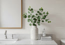 Minimalist Bathroom with Green Eucalyptus in White Vase and Marble Surface