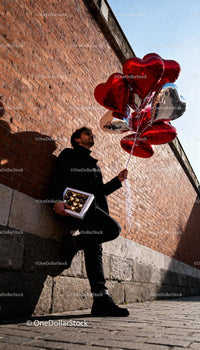 Man Holding Heart Balloons and Chocolates on Sunny Day