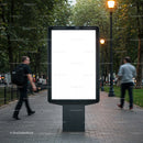 Urban street lightbox display with pedestrians walking by