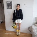 Young Woman Wearing Black Oversized Sweatshirt and White Shorts Indoors