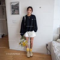 Young Woman Wearing Black Oversized Sweatshirt and White Shorts Indoors
