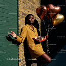 Woman with heart balloons and chocolate box by brick wall