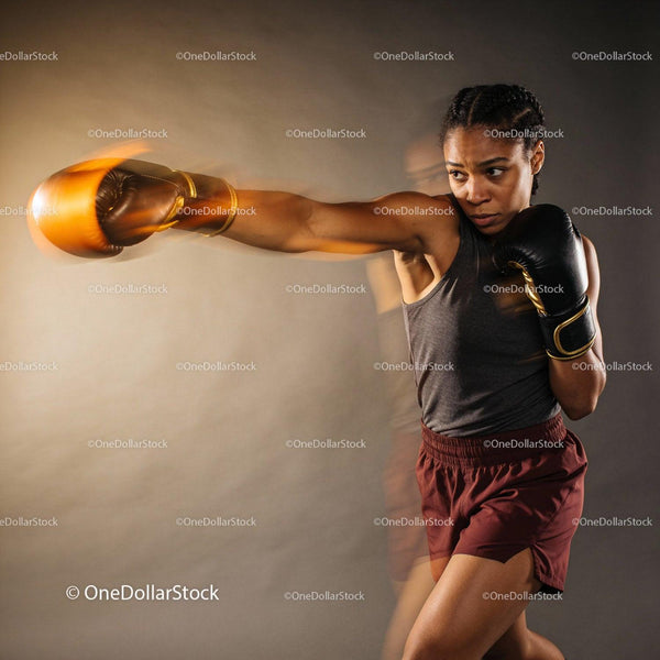 Focused female boxer delivering powerful punch in motion