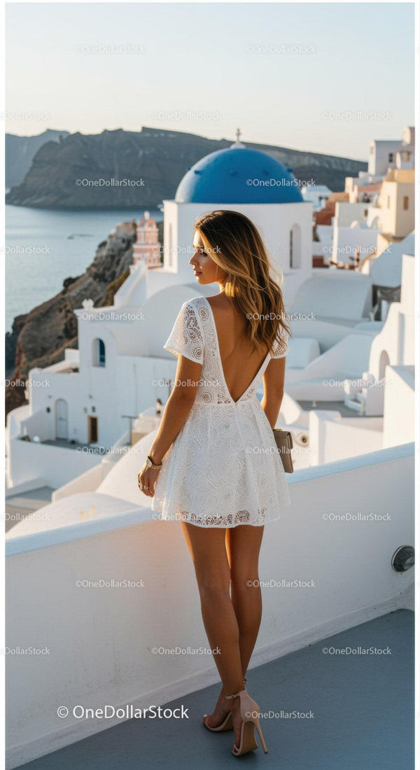 Kobieta w Białej Sukience Podziwiająca Zachód Słońca na Santorini