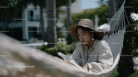Woman Relaxing and Reading in a Hammock Amidst Greenery