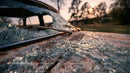 Abandoned Vintage Car with Broken Glass at Sunset