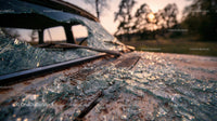 Abandoned Vintage Car with Broken Glass at Sunset
