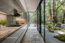 Modern Kitchen with Floor-to-Ceiling Glass Walls Overlooking Serene Garden