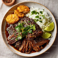 Savory Beef Dish with Rice, Plantains, and Fresh Lime Wedges