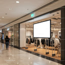 Empty clothing store display with illuminated ad board