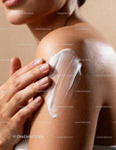 Close-up of woman applying moisturizing cream on shoulder