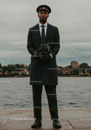 Confident doorman standing by the waterside in uniform